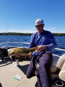 Maine fishing guide Charlie McGee struggling to hold a massive fish with his two hands.